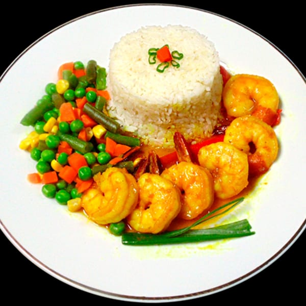 A Jamaican dish with shrimp in sauce, white rice, and mixed vegetables on a white plate.